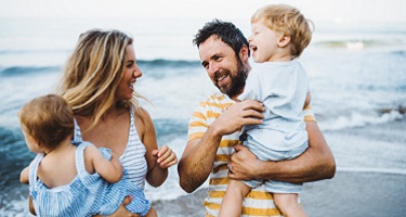 Ehepaar mit zwei Kindern am Strand