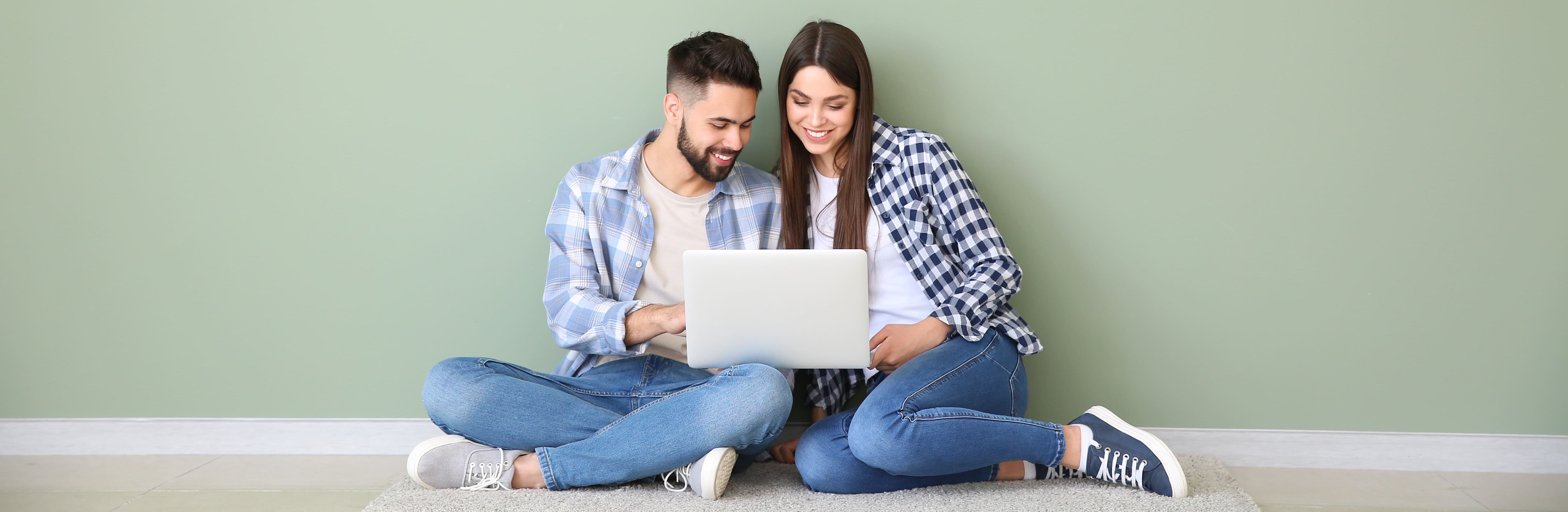 Paar sitzt am Laptop