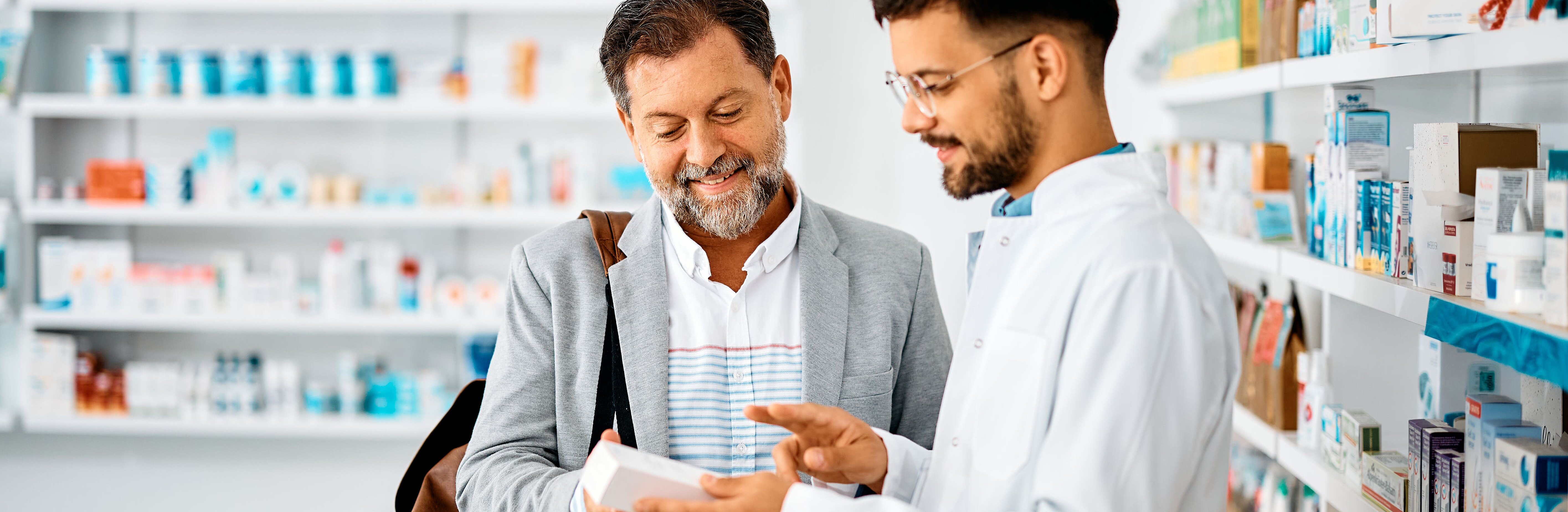 Mann lässt sich in der Apotheke über Medikamente beraten.