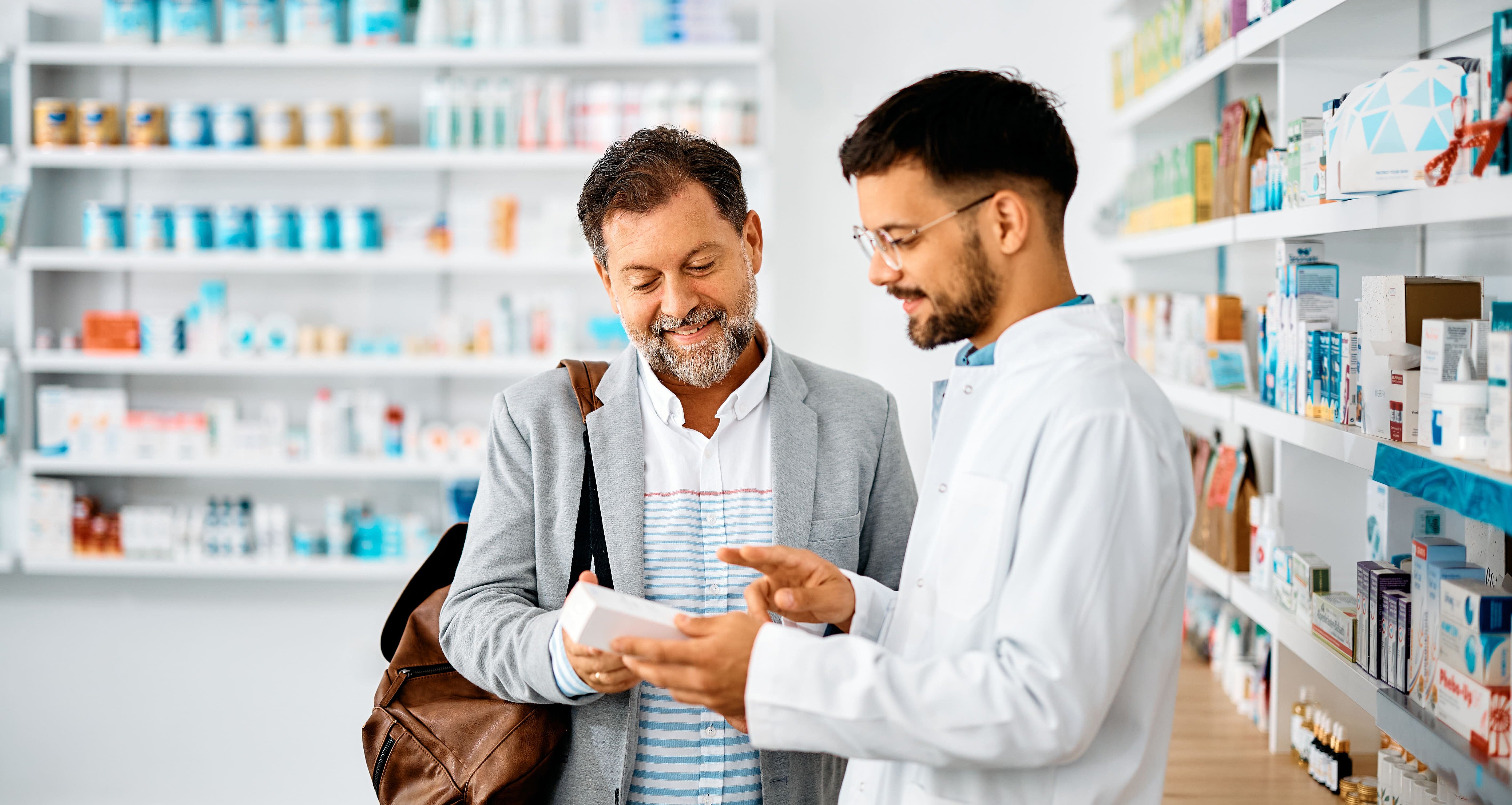 Mann lässt sich von Apotheker zu Arzneimitteln beraten.