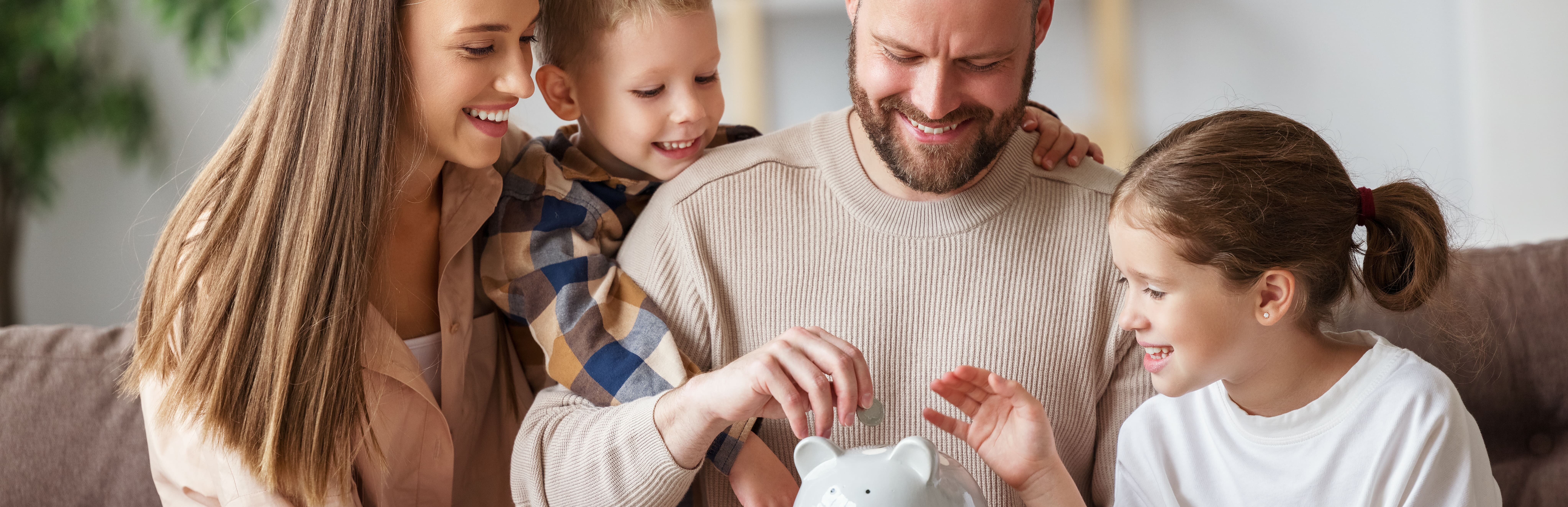 Familie steckt Geldmünzen in Sparschwein