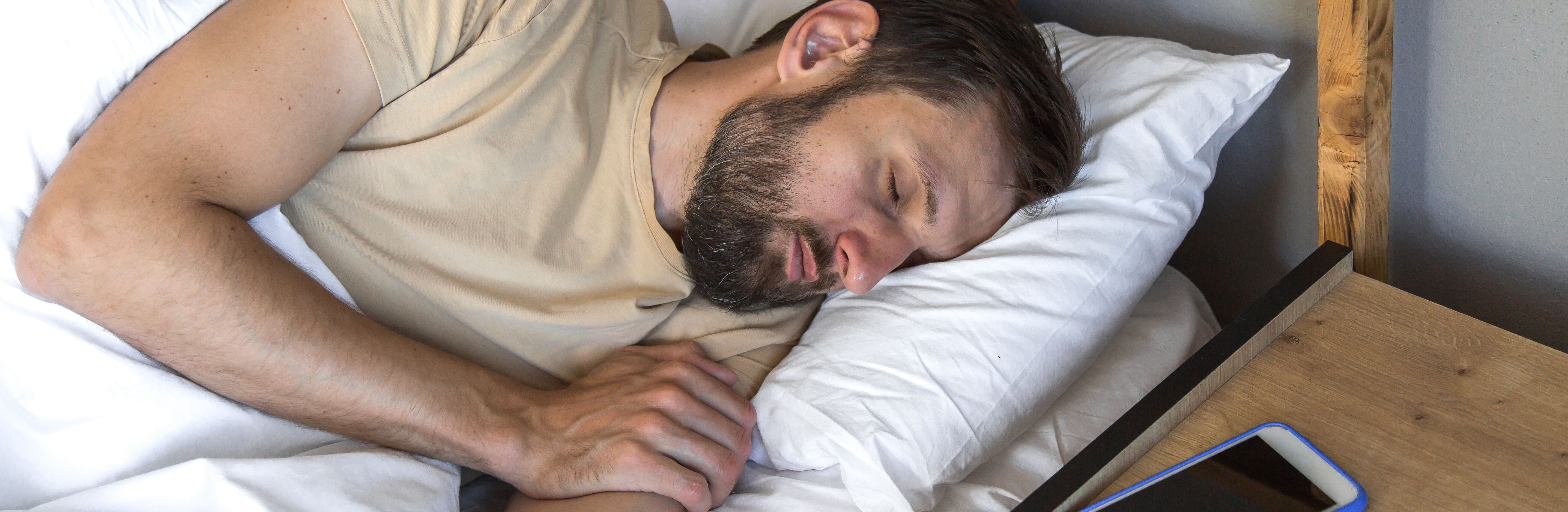 Mann schläft entspannt im Bett