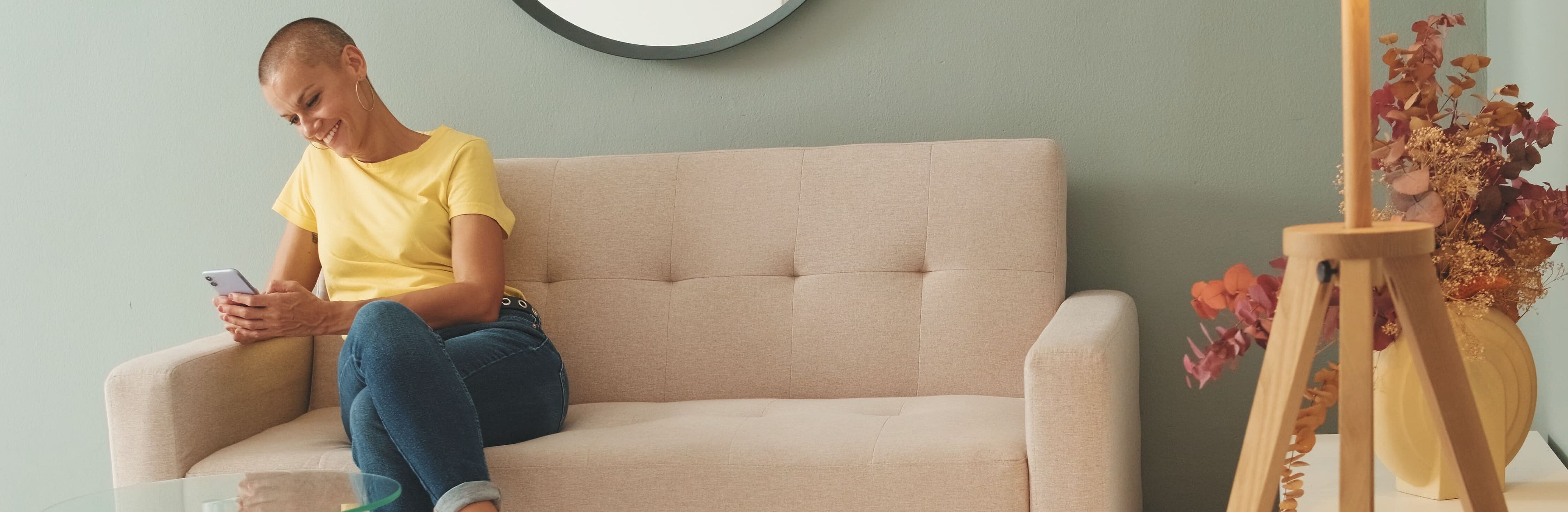 Frau mit kurzen Haaren sitzt auf Sofa