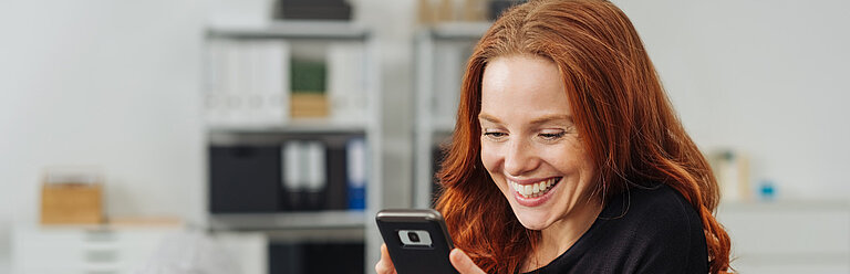 Frau mit Handy zu Hause